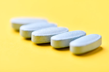 Pills on a yellow background. Focus on foreground, soft bokeh.の写真素材
