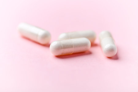 Capsules of medicine on a pink background, close-up