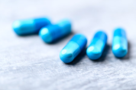 Blue pills on a wooden background. Focus on foreground, shallow depth of field.