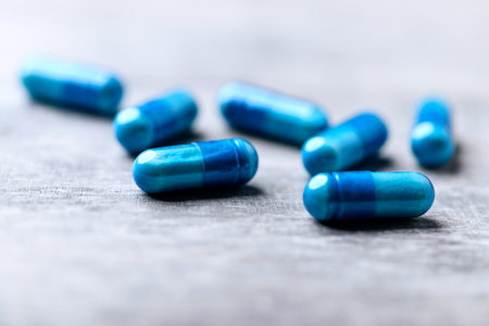 Blue pills on a gray background. Focus on foreground, shallow depth of field.の写真素材