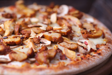 Pizza with mushrooms and cheese on a wooden background. Selective focus.の写真素材