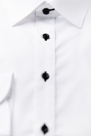 Close up of a white shirt with black buttons. Shallow depth of field.の写真素材