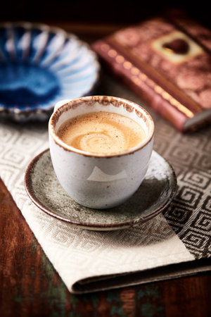 Coffee cup and book on old wooden table. Selective focus.の写真素材