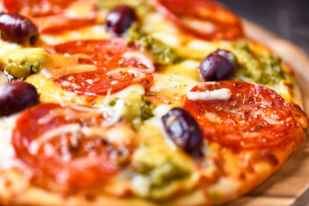 Pizza with mozzarella cheese, olives and tomato on wooden tableの写真素材