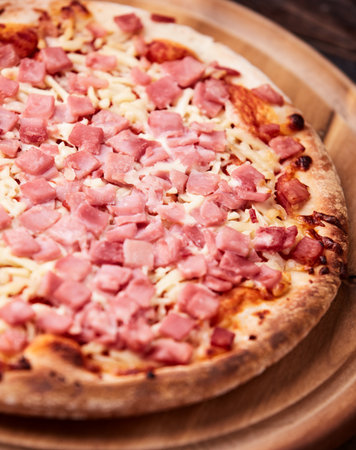 pizza with ham and cheese on a dark wooden background. tinting. selective focusの写真素材