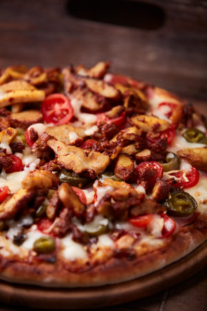 Pizza with meat, cheese and olives on a wooden backgroundの写真素材