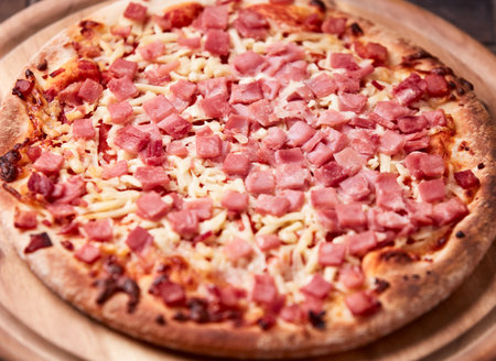Pizza with ham and cheese on a wooden table. Top viewの写真素材