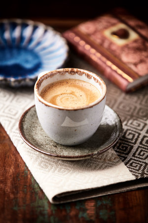 Coffee cup and old book on wooden table. Vintage style.の写真素材