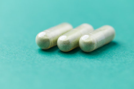 Capsules of dietary supplements on a turquoise background.