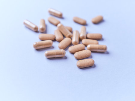 Pills on a blue background. Focus on foreground, soft bokeh.