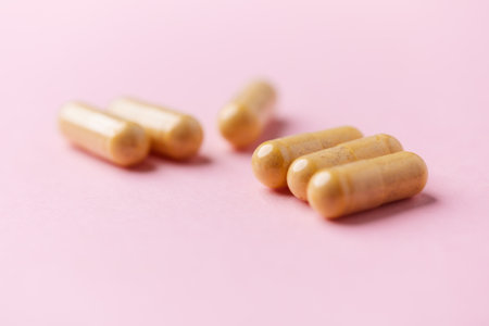 Pills on pink background. Focus on foreground, soft bokeh.