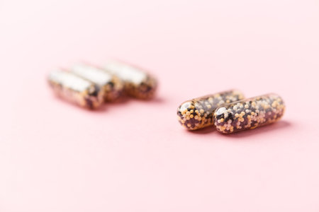 Capsules of vitamins on a pink background. Copy space.