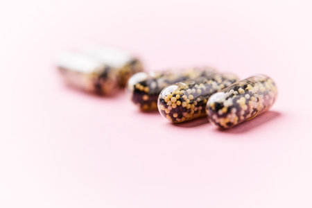 Capsules of omega 3 fish oil on a pink background.