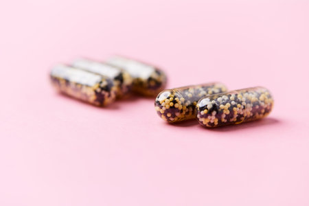 Capsules of omega 3 fish oil on a pink background.
