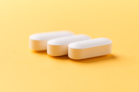 Pills isolated on yellow background. Focus on foreground, soft bokeh.