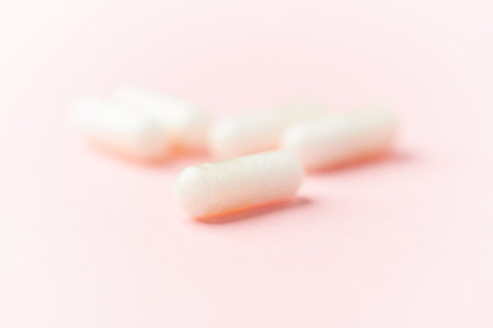 White chewing gum on pastel pink background. Minimal concept.
