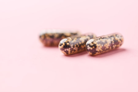 Capsules of dietary supplements on a pink background with copy spaceの写真素材