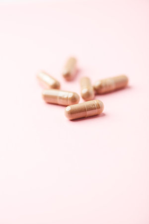 Close up of medicine pills on pink background. Healthcare and medical concept.