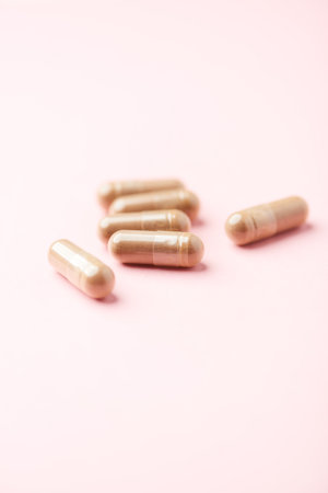 Capsules of medicine on a pink background. Close up.