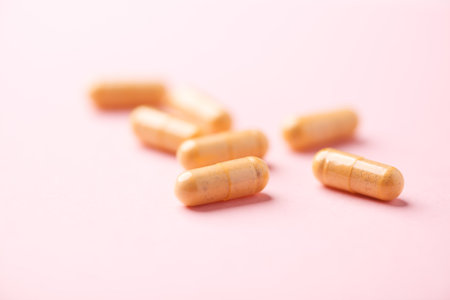 Capsules of medicine on a pink background. Copyspace.