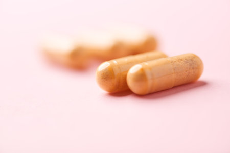 Close-up of pills on pink background. Focus on foreground.