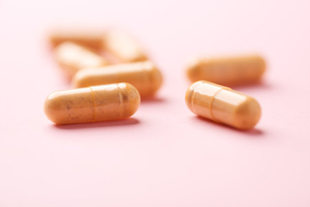 Capsules of medicine on a pink background. Focus on foreground.の写真素材