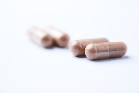 Capsules on a white background. Focus on foreground, soft bokeh.