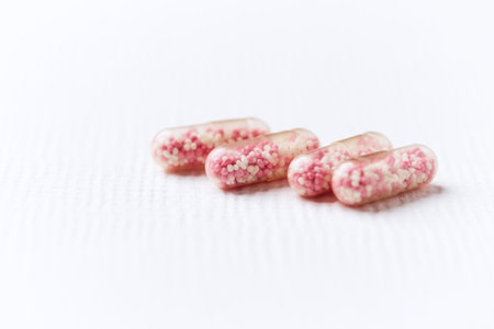Close up of pink pills on a white background. Selective focus.