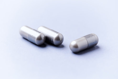 Medical capsules on a light blue background. Focus on foreground, soft bokeh.