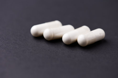 White pills on a black background. Focus on foreground, soft bokeh.の写真素材