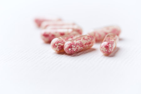 Close up of pink pills on white background. Focus on foreground.の写真素材
