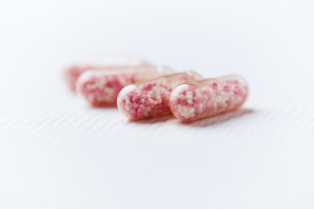 Close up of a group of pink capsules on a white background.の写真素材