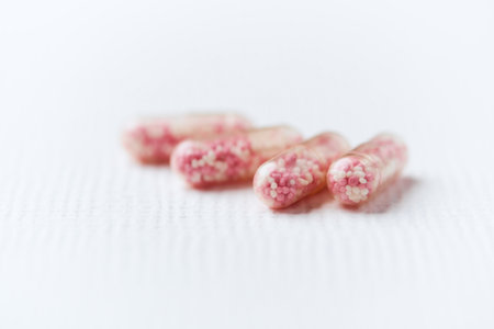 Close up of pink pills on white background. Focus on foreground.の写真素材