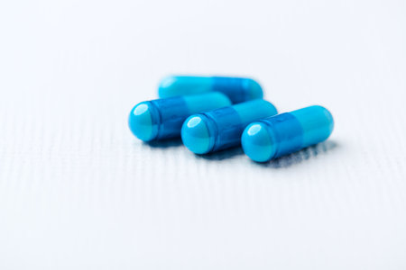 Blue pills on white background. Focus on foreground, soft bokeh.の写真素材