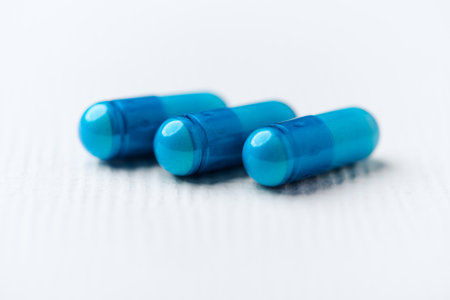 Blue pills on a white background. Focus on foreground, soft bokeh.の写真素材