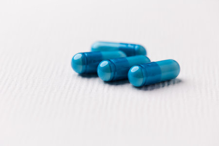 Blue pills on a white background. Focus on foreground, soft bokeh.の写真素材