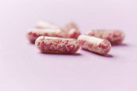 Heap of pink pills on purple background. Focus on foreground.の写真素材