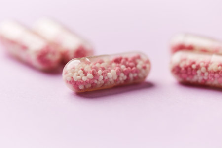 close up of pink pills on pink background with copy space, healthcare concept