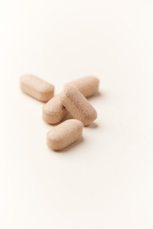 Pills on a white background. Focus on foreground, soft bokeh.
