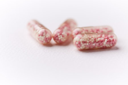 Close up of pink pills on white background. Focus on foreground.
