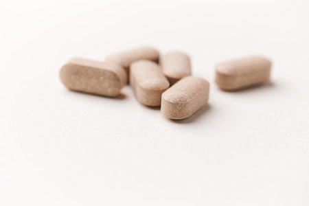 Heap of pills on white background. Focus on foreground, soft bokeh.の写真素材