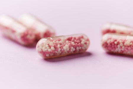 close up of pink and white pills on pink background with copy spaceの写真素材