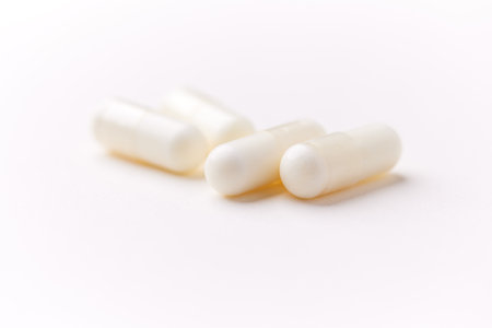 White pills on white background. Focus on foreground, soft bokeh.