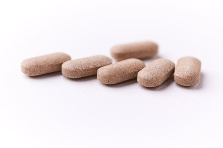 Close up of pills on white background. Focus on foreground, soft bokeh.の写真素材