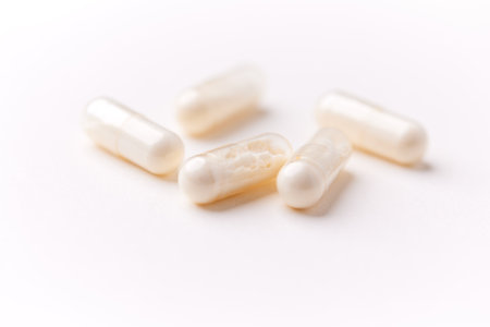 Close up of white pills on white background. Focus on foreground, soft bokeh.