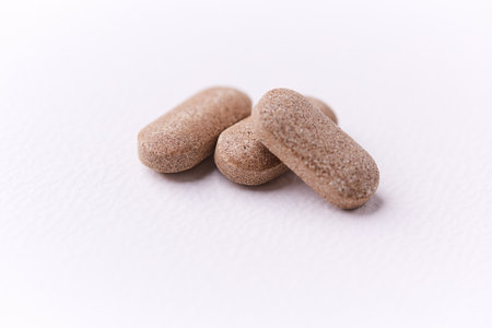 Close up of pills on white background. Focus on foreground, soft bokeh.の写真素材
