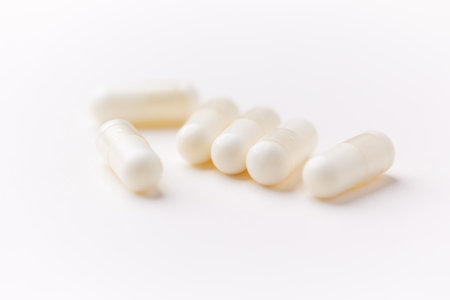 White pills on white background. Focus on foreground, soft bokeh.