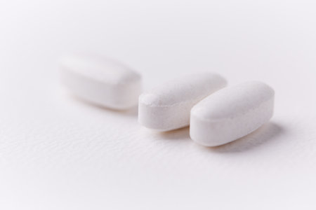 Close up of white pills on white background. Focus on foreground, soft bokeh.の写真素材