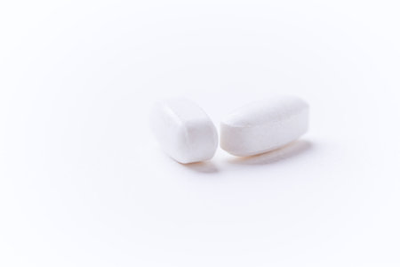 Creatine tablets on paper background. Soft focus. Close up. Copy space.
