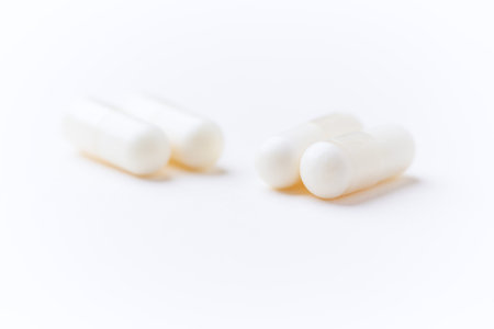 White pills on a white background. Focus on foreground, soft bokeh.